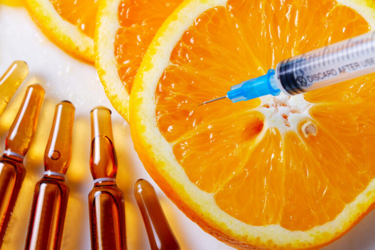 witamina-c-naturalne-serum-przeciwstarzeniowe-i-strzykawka-z-plastrami-owocow-pomaranczowych